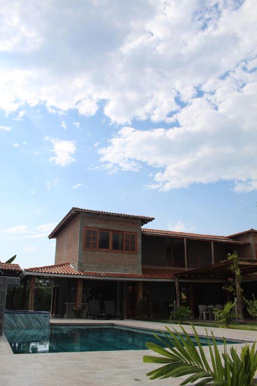 uma casa com uma piscina em frente em Finca Hotel Casa Lupe En Santa Elena em El Cerrito