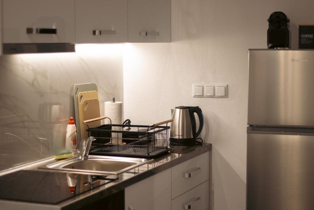 a kitchen counter with a sink and a refrigerator at Emily Apartments 3 in Chrysoupolis