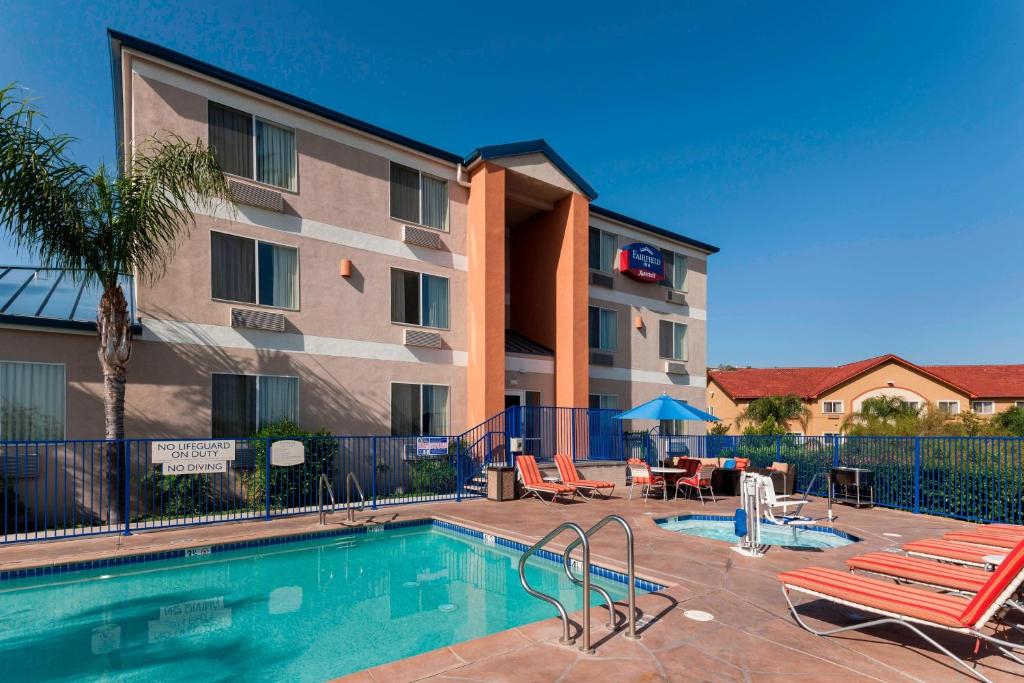 einem Pool vor einem Gebäude mit einem Hotel in der Unterkunft Fairfield Inn by Marriott Santa Clarita Valencia in Santa Clarita