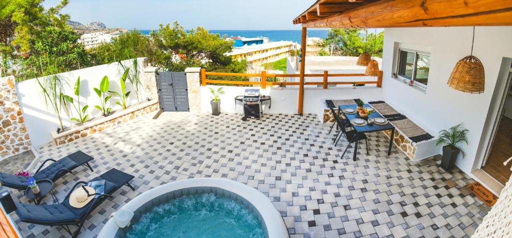 a patio with a pool and a table and chairs at Casa Zoe Luxurious Retreat in Archangelos