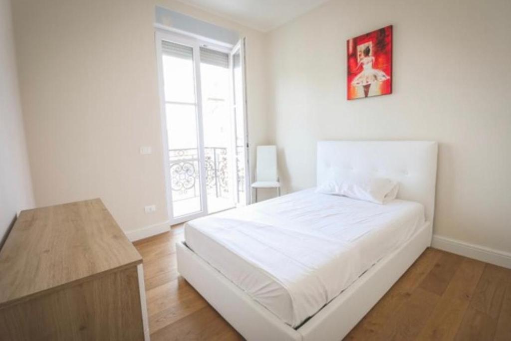 - une chambre blanche avec un lit blanc et une fenêtre dans l'établissement Antonella Luxury Art Apartment, à Viareggio