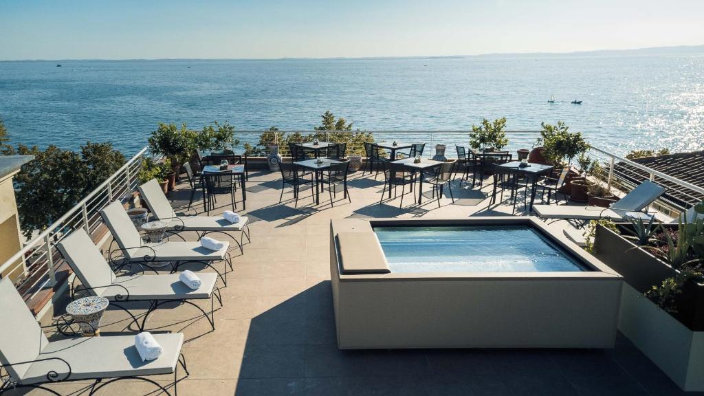 un balcon avec des tables et des chaises ainsi qu'une piscine dans l'établissement Hotel Giardinetto, à Garde