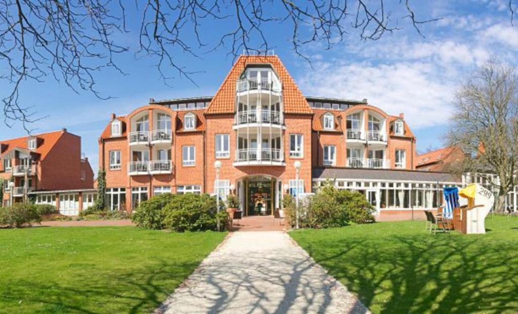 a large brick building with a pathway in front of it at Ringhotel Hohe Wacht in Hohwacht