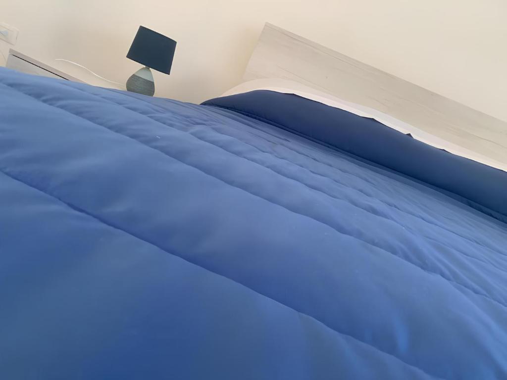 a close up of a bed with blue sheets at Ippocampo alba e tramonto in Ippocampo