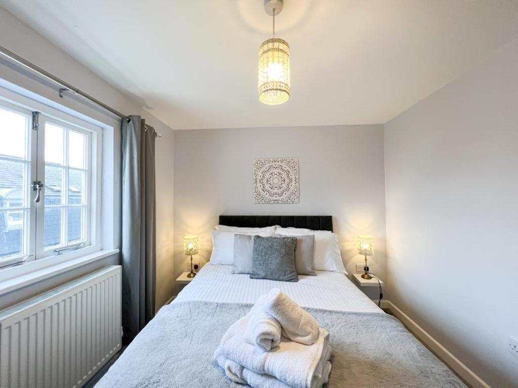 a bedroom with a large white bed with two lamps at Suitely Stays Berkeley Apartment 5 in Cheltenham