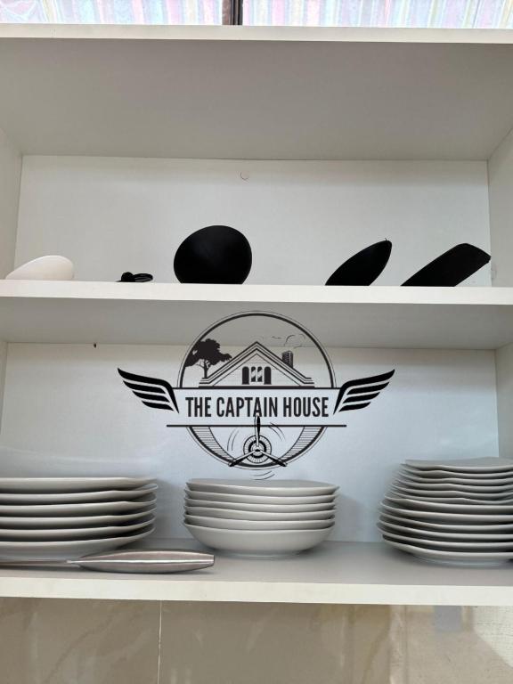uma prateleira com o letreiro da casa dos Carrini e as placas em The Captain House em Pucallpa