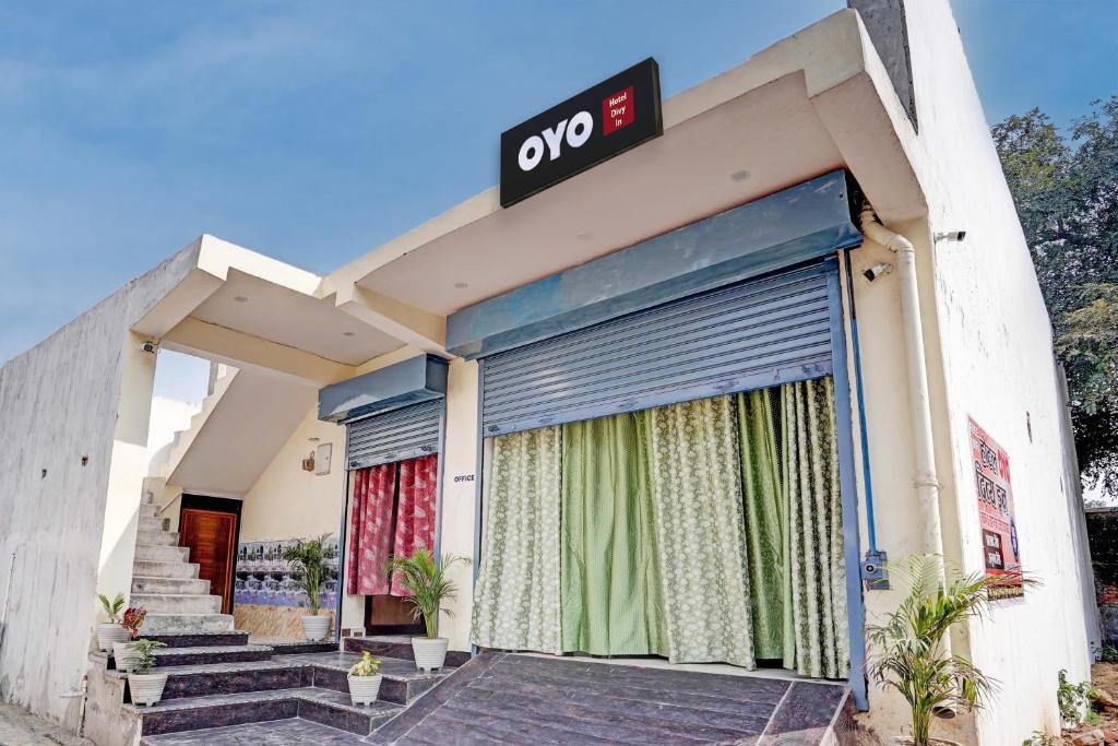 OYO Flagship Hotel Divy inn في Prayagraj: مبنى عليه لافتة مفتوحة