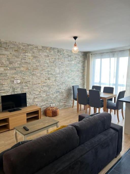 un salon avec un canapé et une télévision dans l'établissement Super 3 pcs et Parking aux portes de Paris et stade de france à proximité des sites touristiques parisiens Montmartre , champs Élysée ,châtelet etc et des transports métro,RER ,wifi disponible, à Saint-Ouen