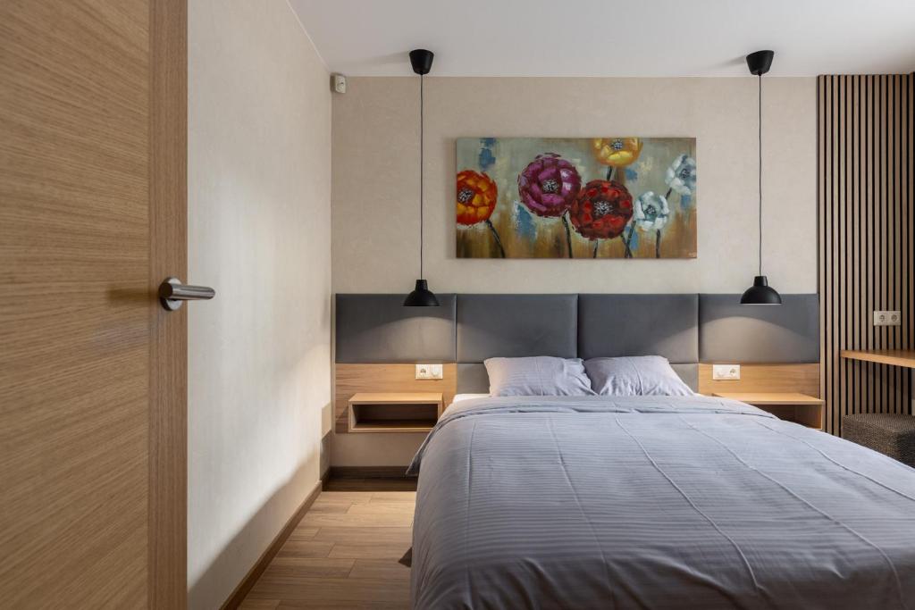 1 dormitorio con 1 cama y una pintura en la pared en Lab1 House en Riga