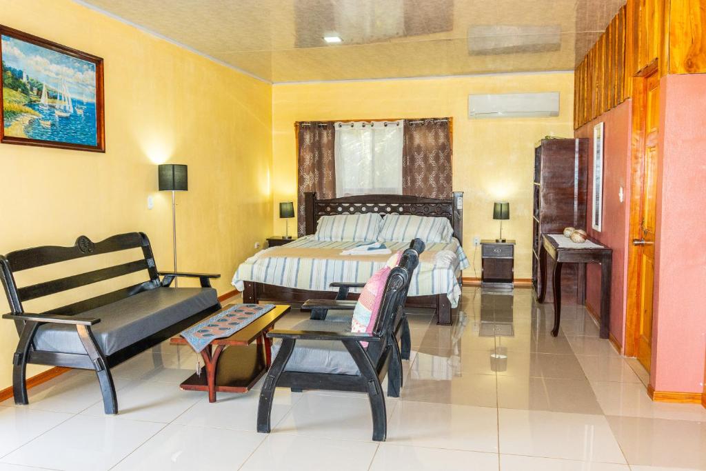 1 dormitorio con 1 cama, 1 silla y 1 mesa en Villa Manolo Ocean and Forest View Hotel, en Drake