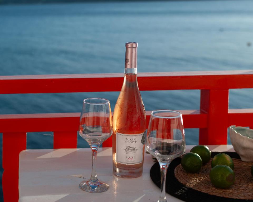 a bottle of wine and two glasses on a table at Fisherman House in Klima