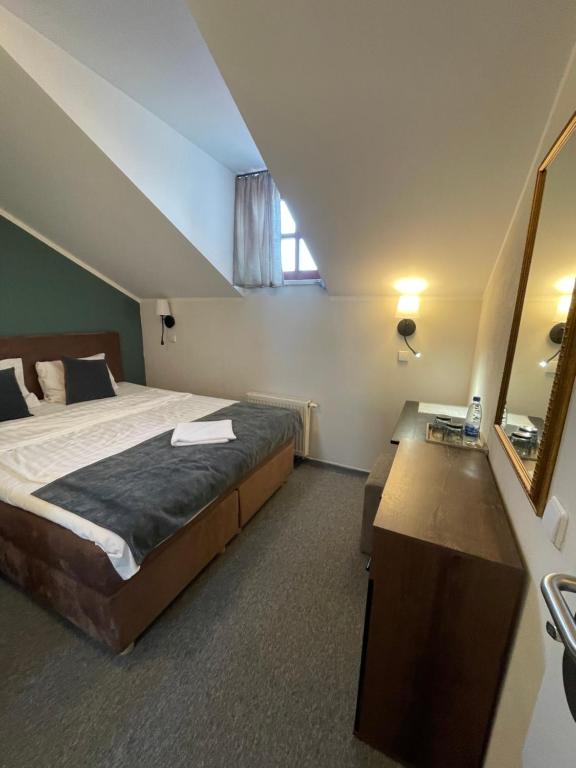 a bedroom with a large bed and a mirror at Apple Economy Hotel in Kaunas