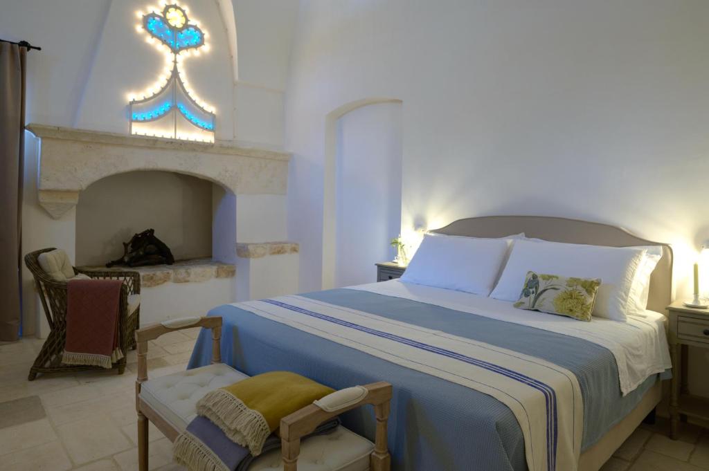 a bedroom with a large bed and a fireplace at Masseria Celeste in Fasano