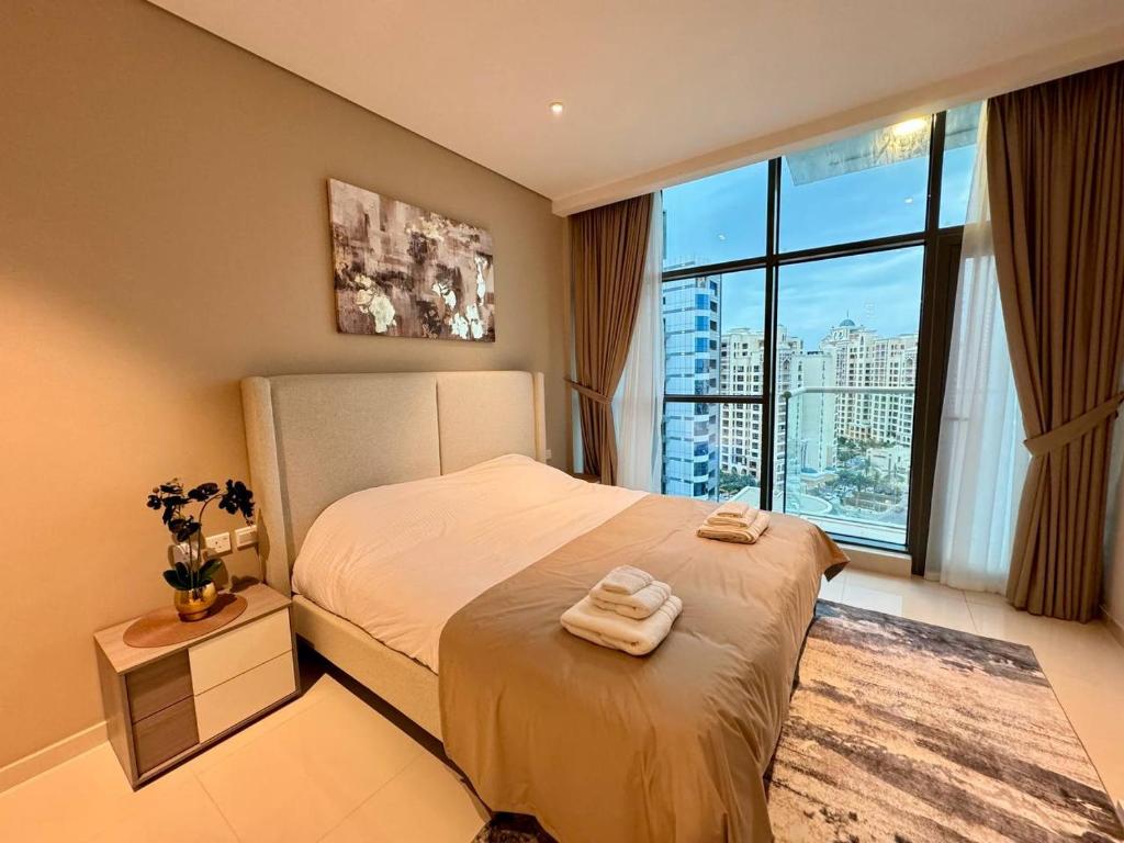 a bedroom with a bed and a large window at Seven Hotel & Apartments at the Palm Jumeirah Studio apartment with awesome view in Dubai