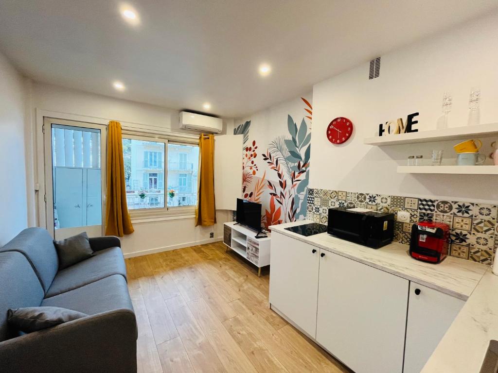 un salon avec un canapé bleu et une télévision dans l'établissement Luxury Studio à Cannes/Croisette, à Cannes