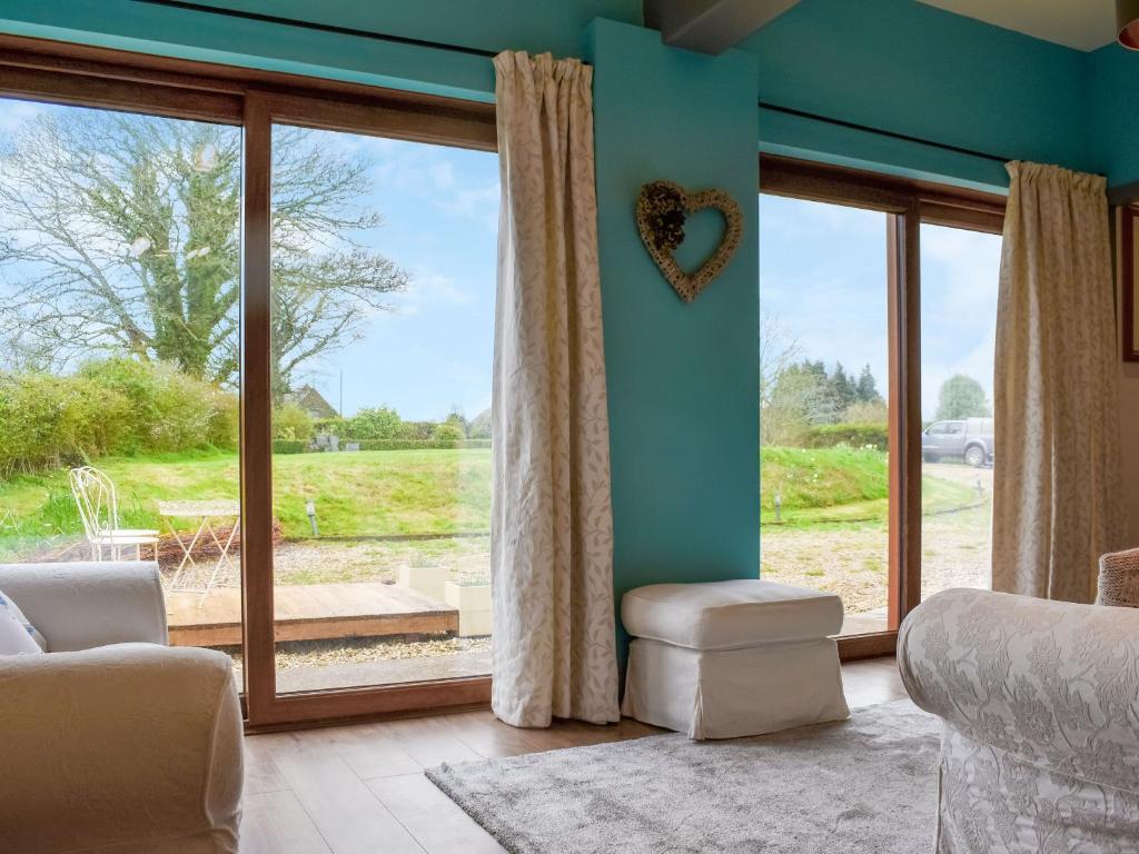 a living room with a large window with a heart on the wall at Ty Ffair Mai Annexe in Llangwm-isaf