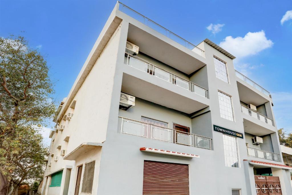 Cet appartement blanc dispose d'un balcon. dans l'établissement Super OYO Flagship SHIVA VALLEY HOTEL, à Varanasi