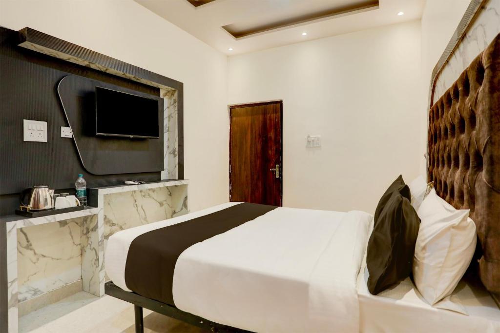 a hotel room with a bed and a television at Super OYO Flagship SHIVA VALLEY HOTEL in Varanasi