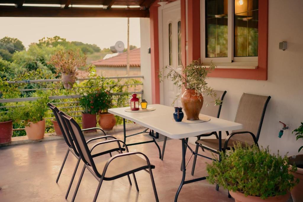 a table and chairs on a patio with a balcony at Evgenias House Ancient Olympia - Happy Rentals in Olympia
