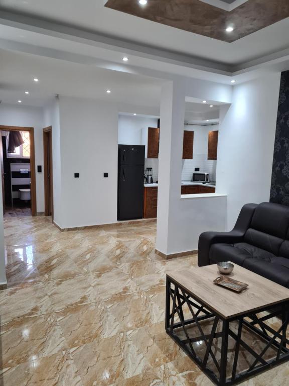ein Wohnzimmer mit einem Sofa und einem Tisch in der Unterkunft Appartement 1 in Hammamet
