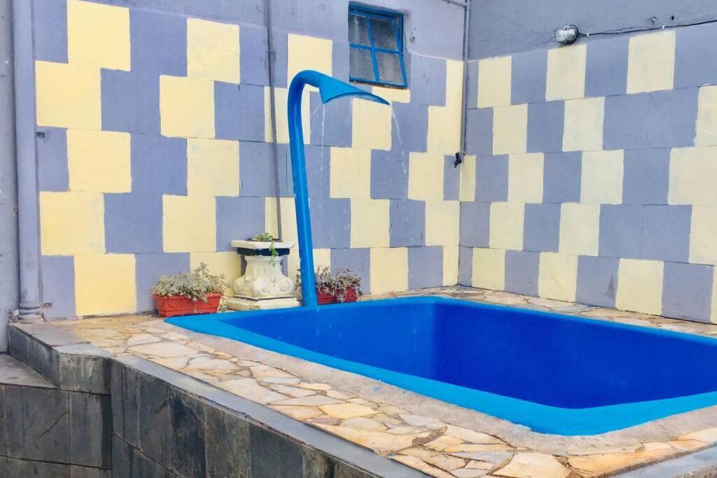eine blaue Badewanne neben einer Wand in der Unterkunft Piscina Casa Floresta/Sta Teresa/Central/Contorno/Serraria Souza Pinto/Area Hospitalar in Belo Horizonte