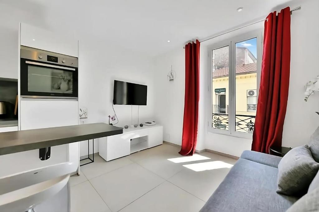 ein Wohnzimmer mit einem Sofa und einem TV in der Unterkunft Nice 2 Rooms in the heart of Cannes in Cannes
