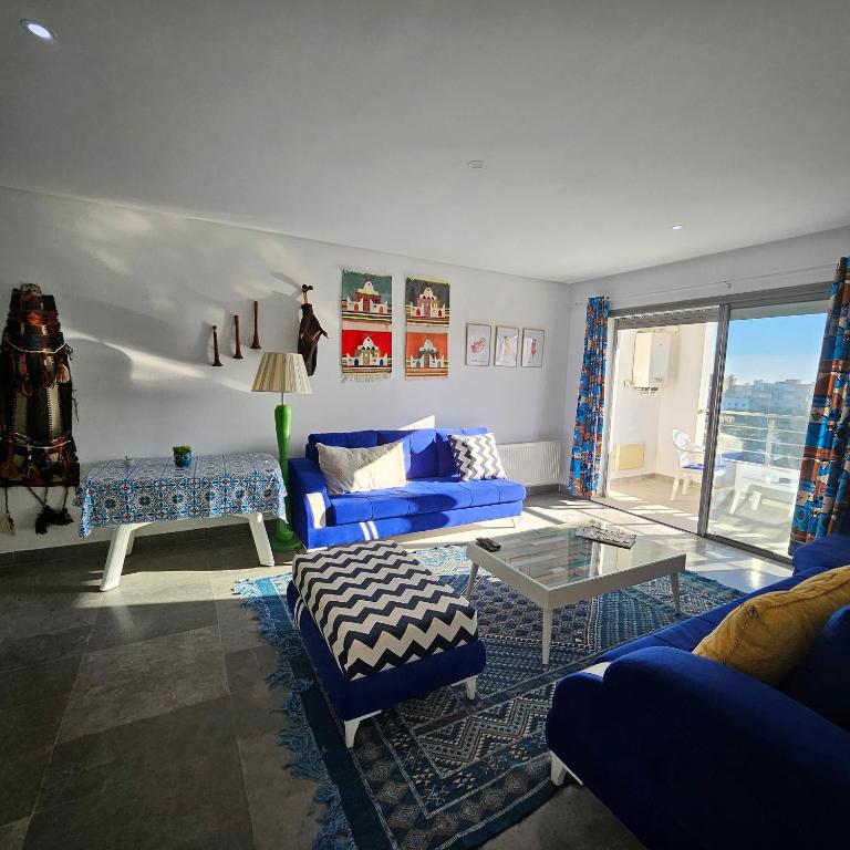 The cozy corner في الحمامات: غرفة معيشة مع أريكة زرقاء وطاولة