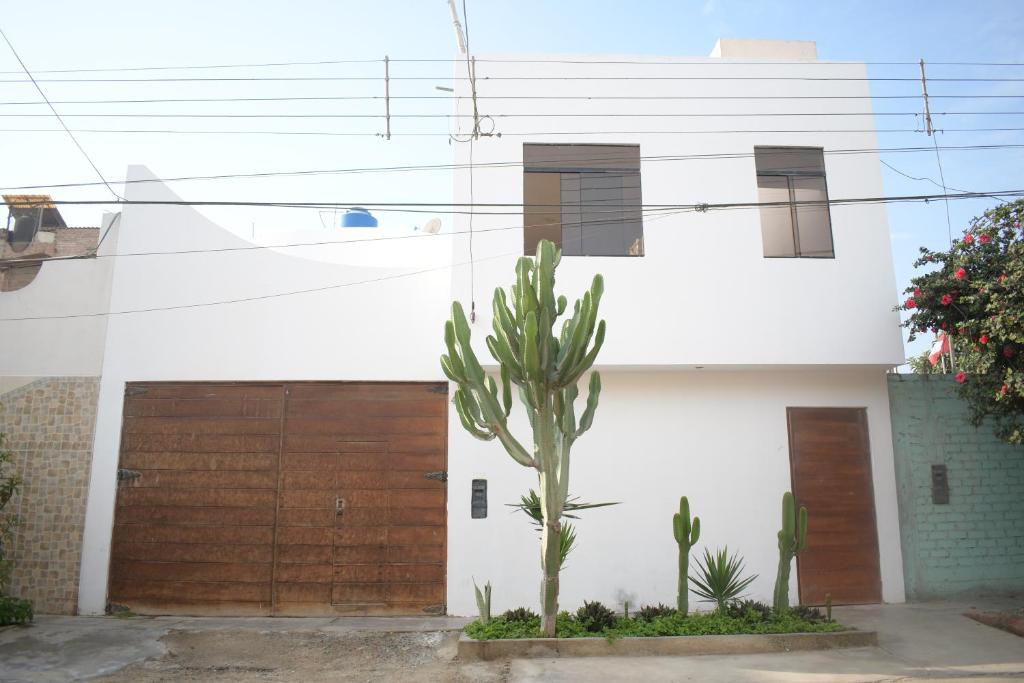 uma casa com um cacto em frente a uma garagem em Chakana House - Hostel Huanchaco em Huanchaco