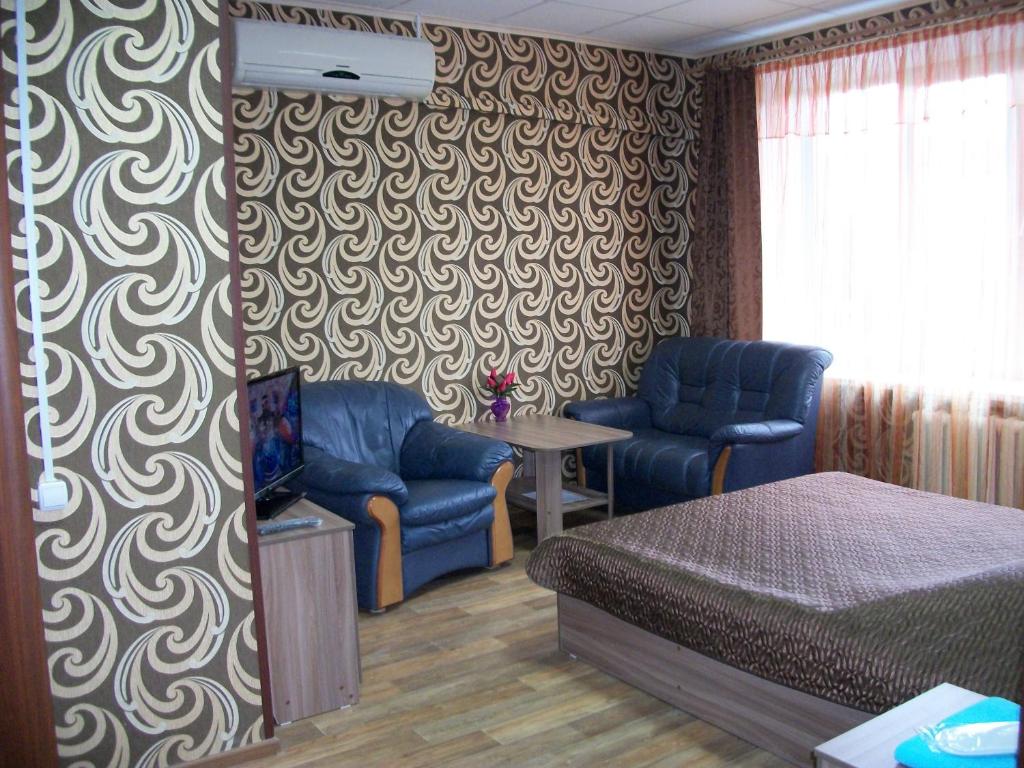 イヴァノヴォにあるAriel гостиницаのベッドルーム1室(ベッド1台、椅子2脚、テーブル付)