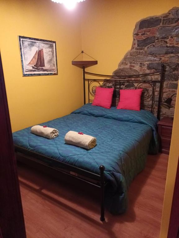 ein Schlafzimmer mit einem Bett mit zwei Kissen darauf in der Unterkunft La Mimosa di Bellano in Bellano