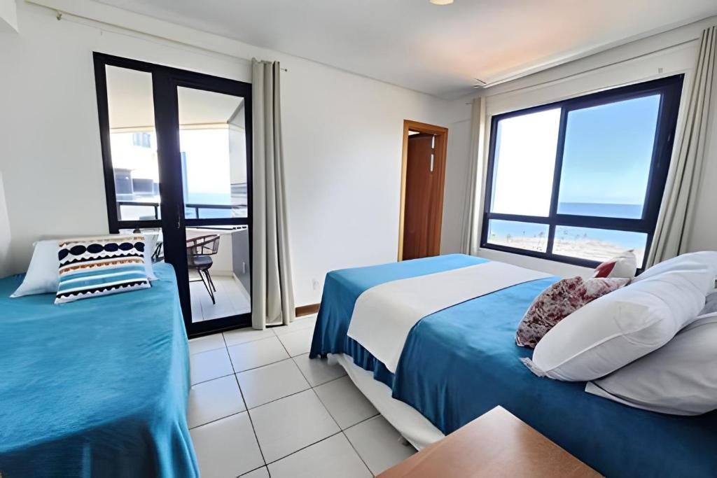 a bedroom with a bed and a view of the ocean at Melhor Vista de Salvador in Salvador