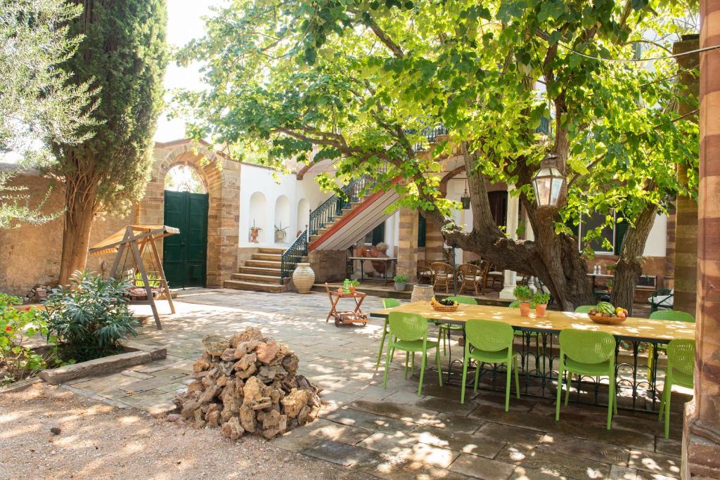 patio ze stołem i krzesłami pod drzewem w obiekcie Calvocoressi Estate w Chios