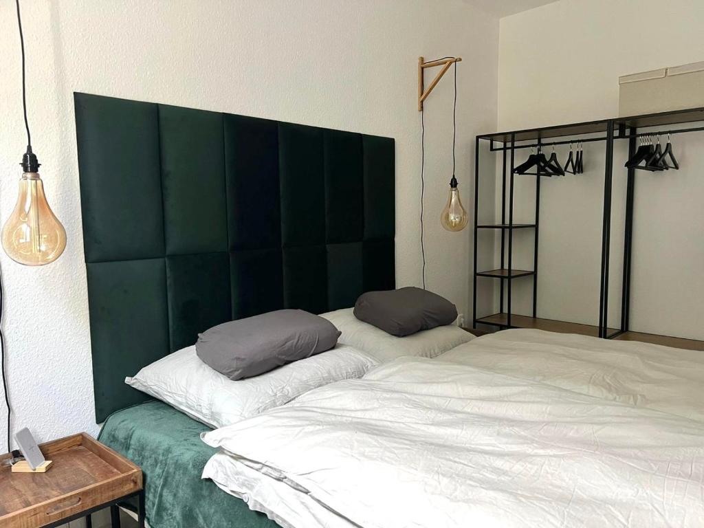 a bedroom with two beds and a green headboard at 100m E-Ladestation - max 4 pers - Düsseldorf - Ruhrgebiet - Pilgerstätte in Velbert