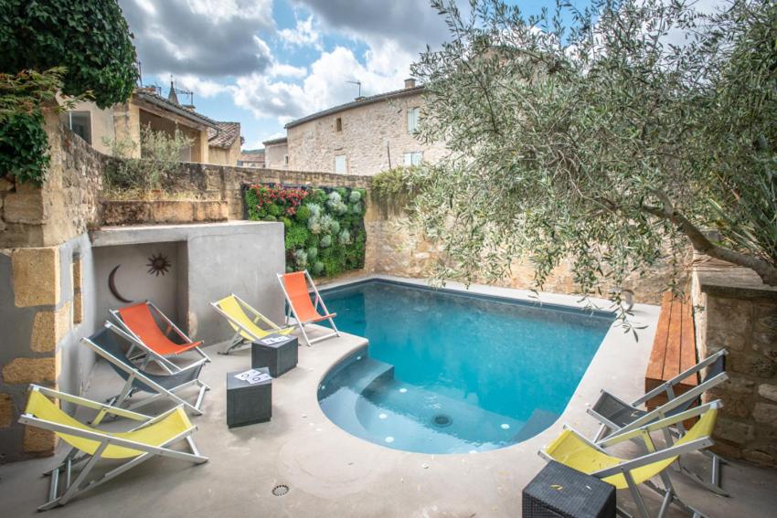 a swimming pool with lounge chairs and a swimming pool at Le Castellas Hotel & SPA - TERITORIA in Collias