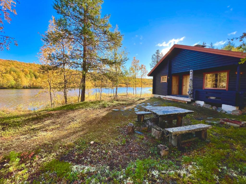 a cabin with a picnic table next to a lake at Villa Aiku in Leppäjärvi