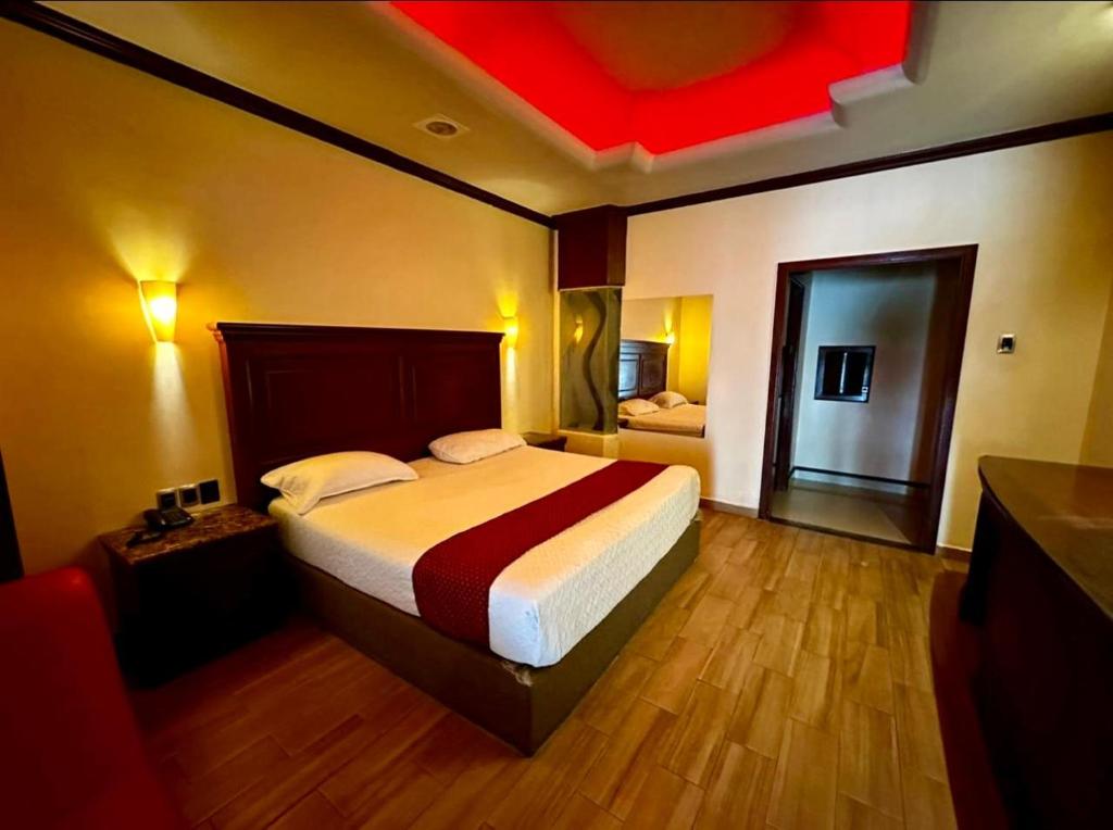 - une chambre avec un lit et un plafond rouge dans l'établissement Hotel Dali, à Reynosa