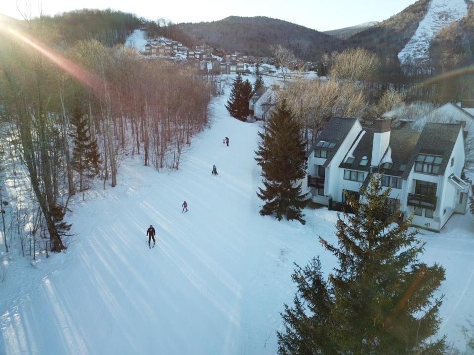 a group of people skiing down a snow covered slope at Sunrise Mountain Village in Killington