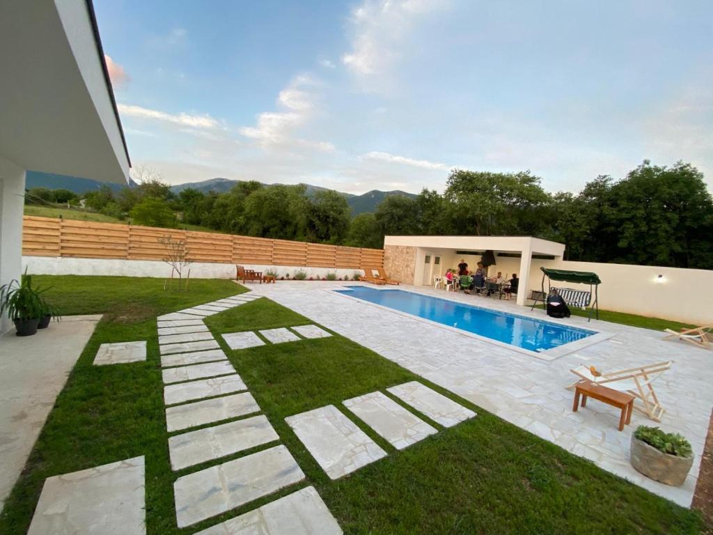 a swimming pool in the backyard of a house at Vestovis Holiday House in Mostar