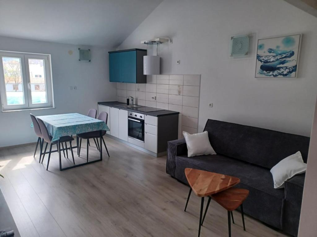 ein Wohnzimmer mit einem Sofa und einem Tisch in der Unterkunft Apartment Roza in Cres