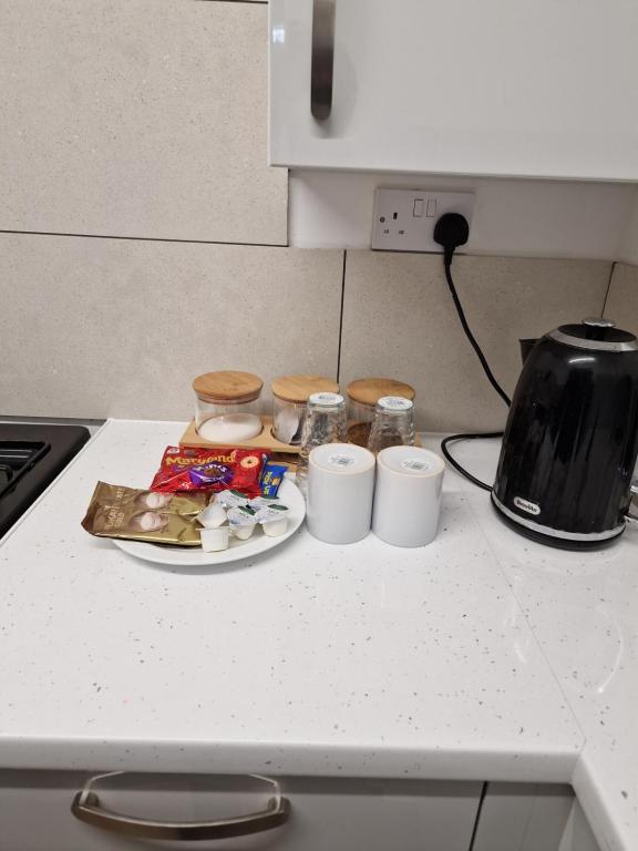a counter top with a plate of food and a toaster at CKB Flat- comfort, cosy, and secure! in Codsall