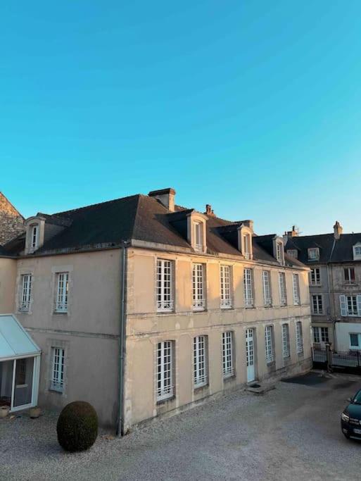 un grand bâtiment avec beaucoup de fenêtres dans l'établissement Appartement au centre ville de Bayeux, à Bayeux