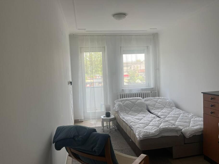 um pequeno quarto com uma cama e uma janela em Small flat in the city heart em Novi Sad