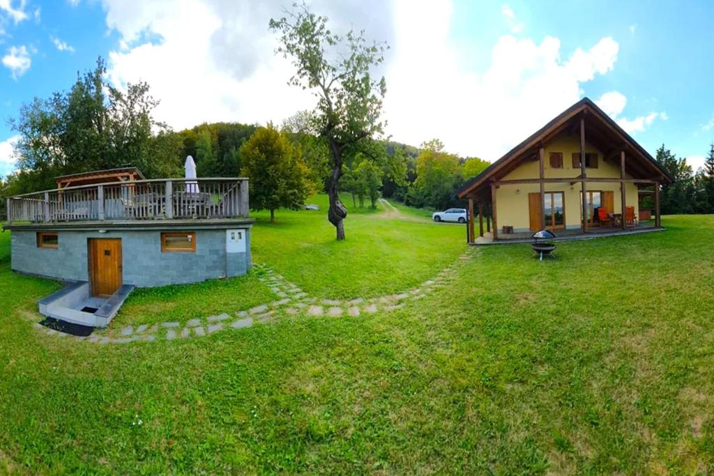 una pequeña casa en un campo al lado de una casa en Forester's Hut With Whirlpool & Sauna - Happy Rentals, en Dol pri Hrastniku