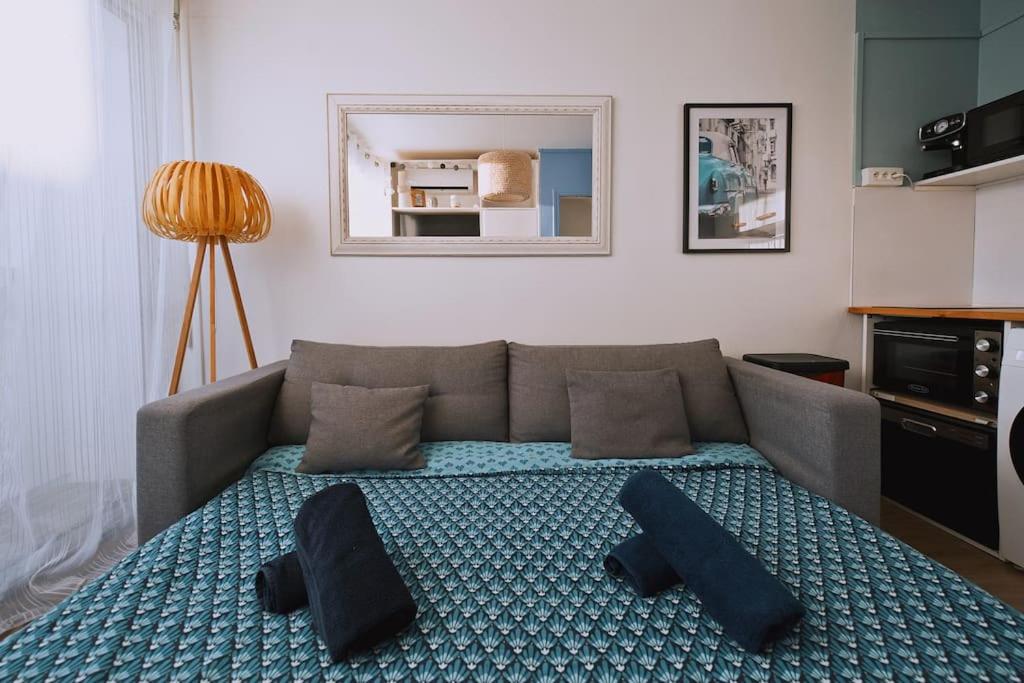 un salon avec un canapé avec des oreillers dans l'établissement Appartement au calme rénové & climatisé en Plein centre du port, à La Grande Motte