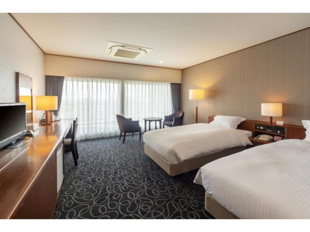 Habitación de hotel con 2 camas y escritorio en Suikoyen Hotel - Vacation STAY 53770v, en Kurume