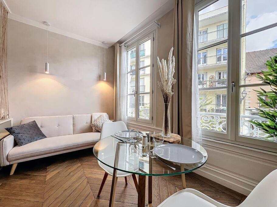 un salon avec un canapé et une table en verre dans l'établissement Camilla, à Troyes