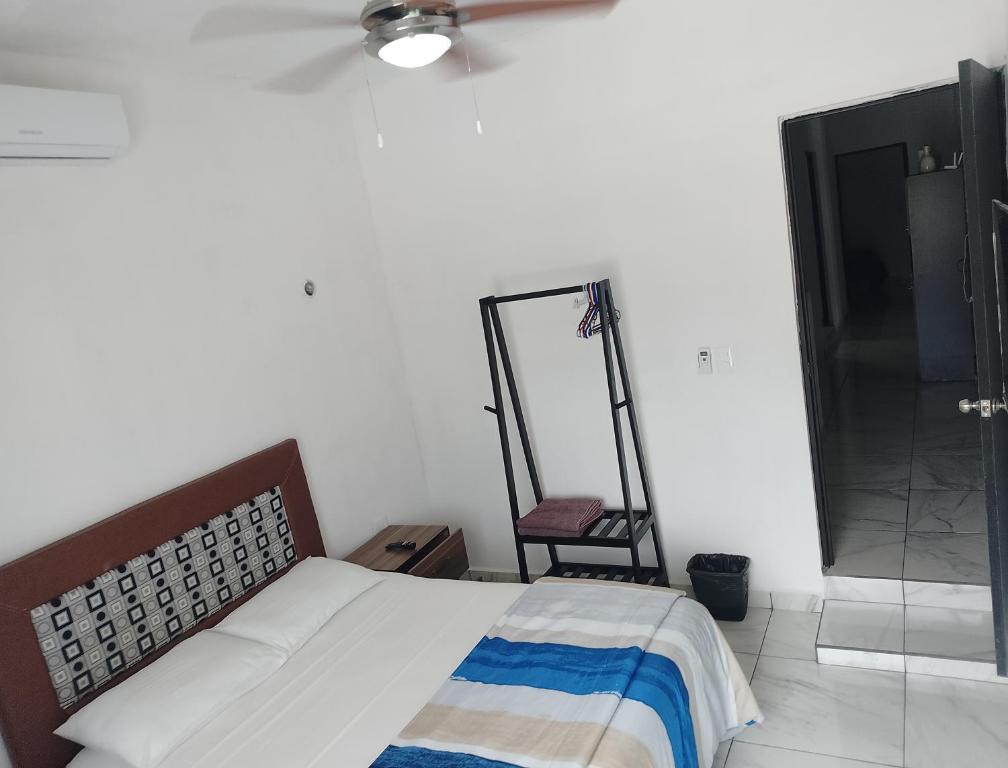 a bedroom with a bed and a mirror and a fan at Hermosos Departamentos in Cozumel