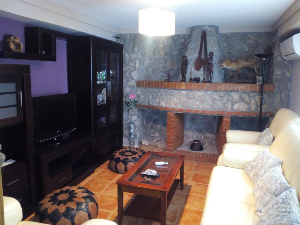 a living room with a fireplace with a couch and a table at Casa Hortensia in Cazorla