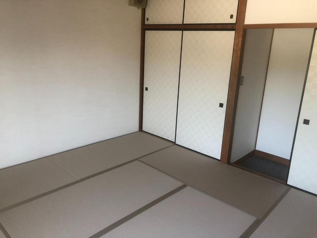 鳥取市にあるGuesthouse Sunaen - Vacation STAY 49050vの白いキャビネット4つと鏡付きの部屋