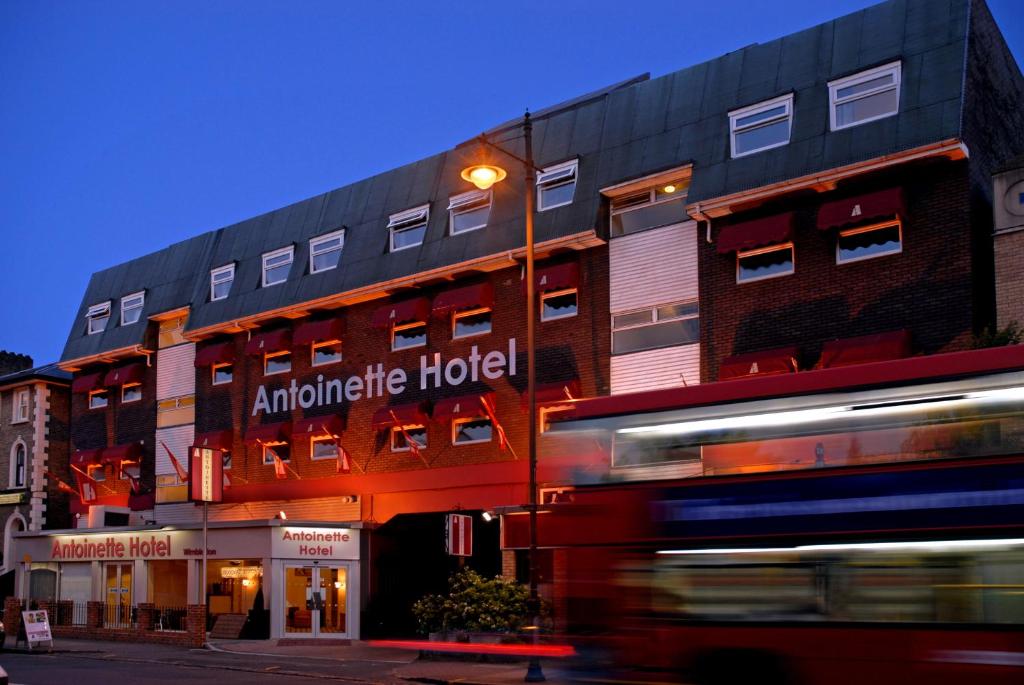 un bâtiment avec un bus devant lui dans l'établissement Antoinette Hotel Wimbledon, à Londres